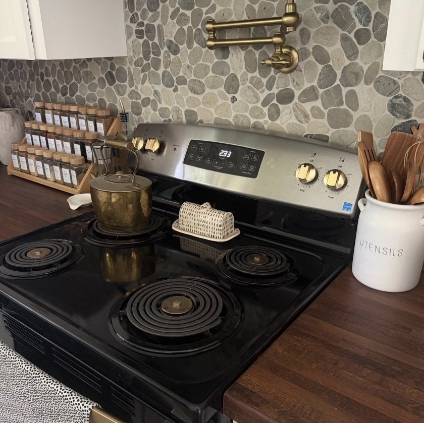 Matte gold knobs on a stainless electric range with a pebble-tile backsplash (customer photo)