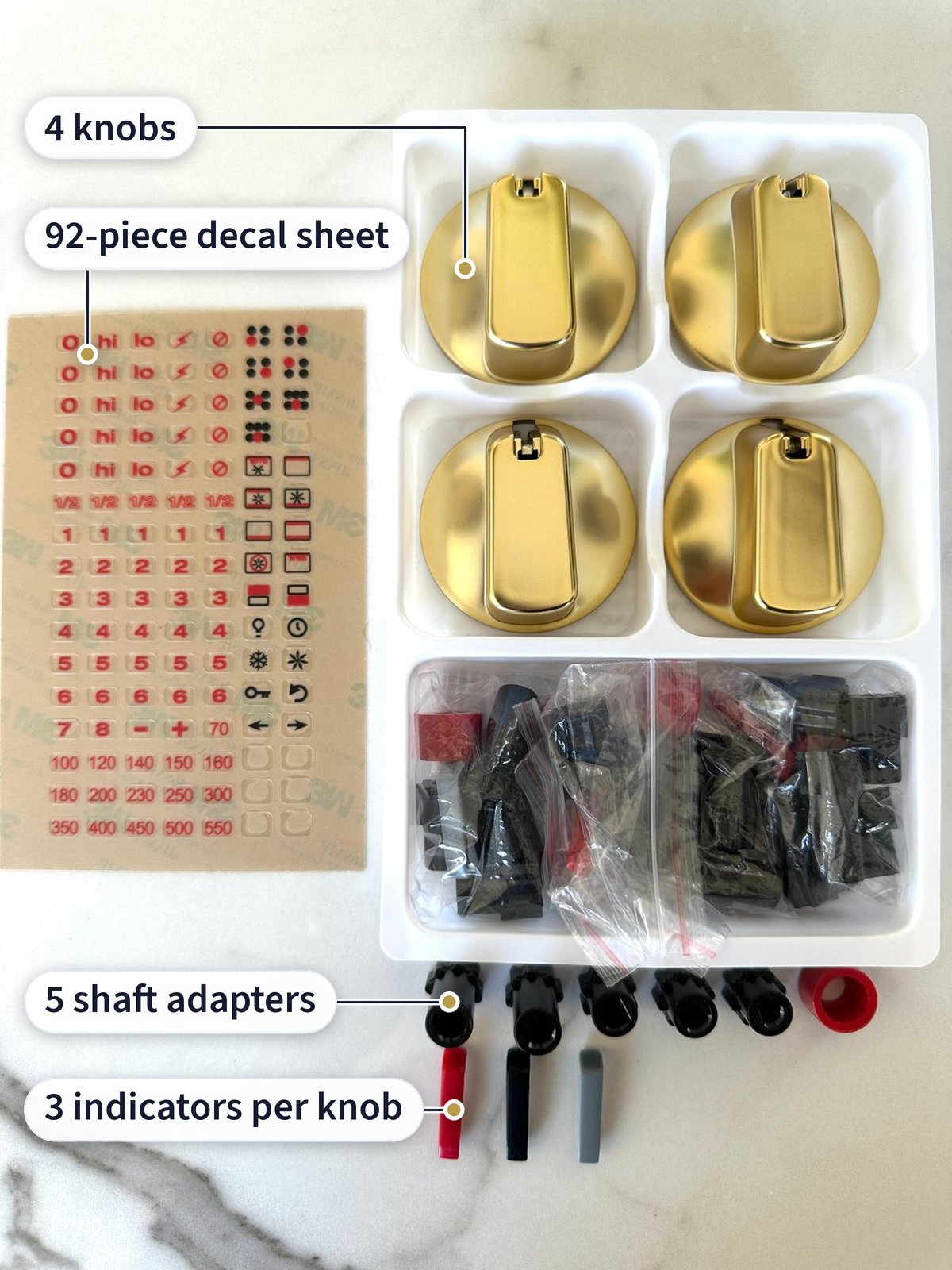 Open box, labeled: 4 matte gold knobs in a tray, a 92-piece decal sheet, 5 shaft adapters and 3 indicator inserts per knob in red, black and gray